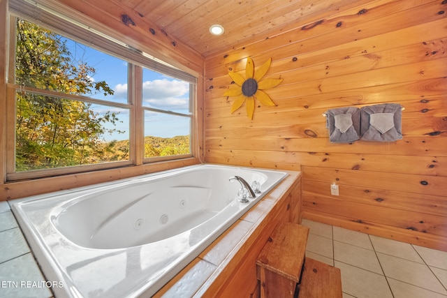 bathroom with wood walls, tile patterned flooring, wooden ceiling, and a bathing tub