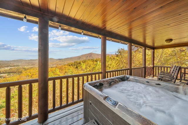 wooden deck with a mountain view and a hot tub