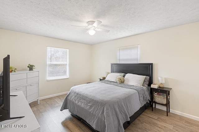 bedroom featuring ceiling fan, a textured ceiling, and light wood-type flooring