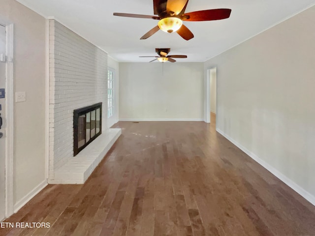 unfurnished living room with ceiling fan, a fireplace, and dark hardwood / wood-style flooring