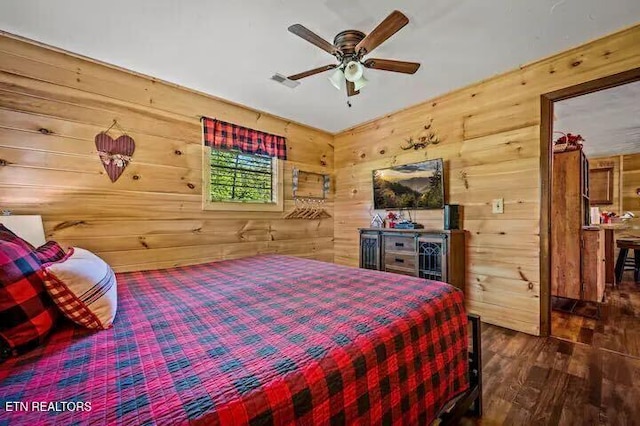 bedroom featuring wooden walls, dark hardwood / wood-style flooring, and ceiling fan