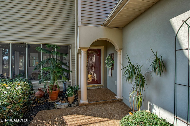 doorway to property featuring stucco siding