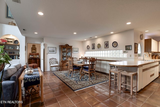 dining space with dark tile patterned floors, visible vents, and recessed lighting