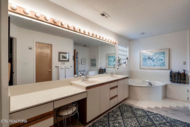 full bathroom featuring a textured ceiling, a sink, visible vents, a bath, and double vanity