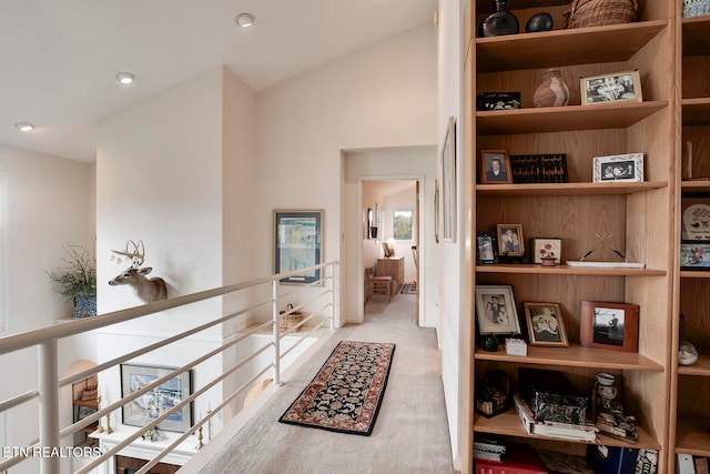 corridor with recessed lighting, vaulted ceiling, and an upstairs landing