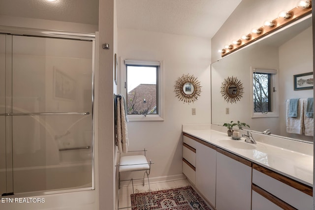 bathroom with vanity, a textured ceiling, an enclosed shower, and lofted ceiling