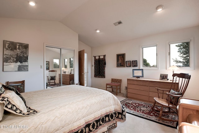 bedroom with a closet, visible vents, vaulted ceiling, and carpet flooring