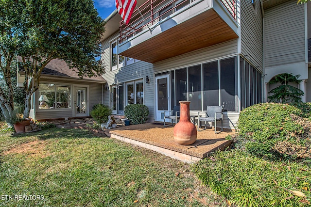 back of property featuring a patio area, a sunroom, and a yard