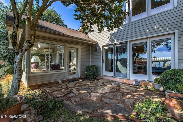 exterior space featuring roof with shingles and a patio area