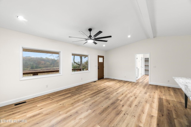 empty room with vaulted ceiling with beams, light hardwood / wood-style floors, and ceiling fan