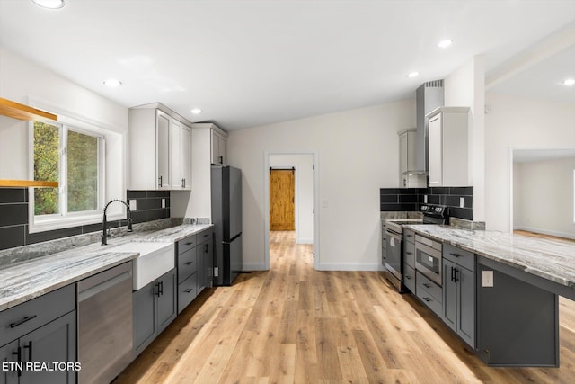 kitchen with sink, gray cabinetry, stainless steel appliances, and light hardwood / wood-style floors