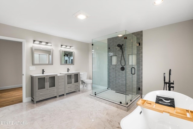 full bathroom featuring vanity, shower with separate bathtub, and toilet