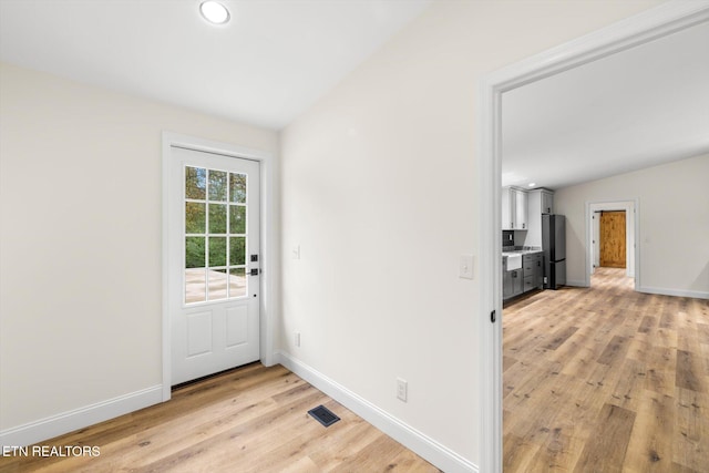 entryway featuring light hardwood / wood-style floors and vaulted ceiling