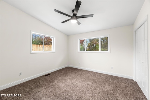 unfurnished bedroom with a closet, ceiling fan, carpet flooring, and lofted ceiling