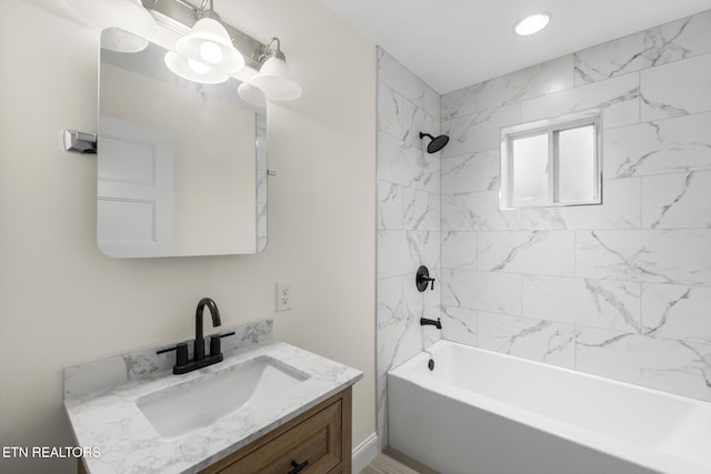 bathroom featuring tiled shower / bath and vanity