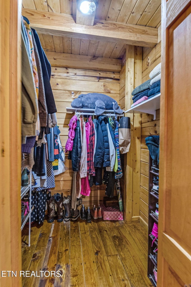 spacious closet with beamed ceiling and dark hardwood / wood-style floors