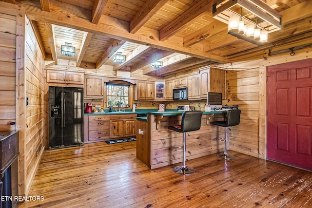 kitchen with black appliances, wood walls, wood ceiling, and dark hardwood / wood-style floors