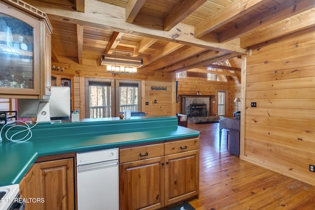 kitchen with a stone fireplace, wooden walls, hardwood / wood-style flooring, white stove, and beamed ceiling