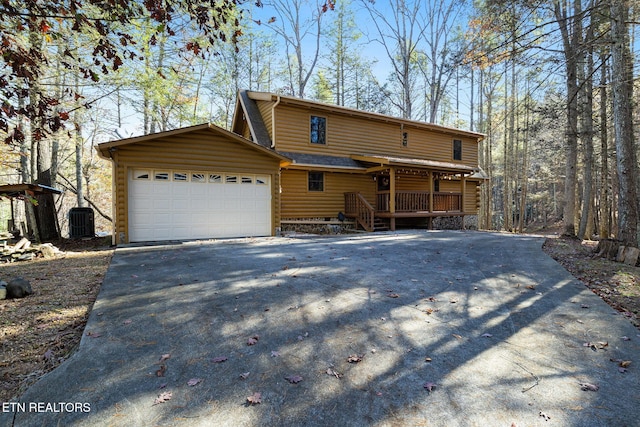 view of front of home with central AC unit and a garage