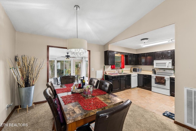 carpeted dining room featuring sink, vaulted ceiling, and ceiling fan