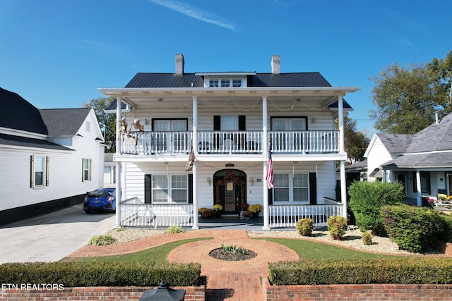 view of front of property featuring a balcony and a porch