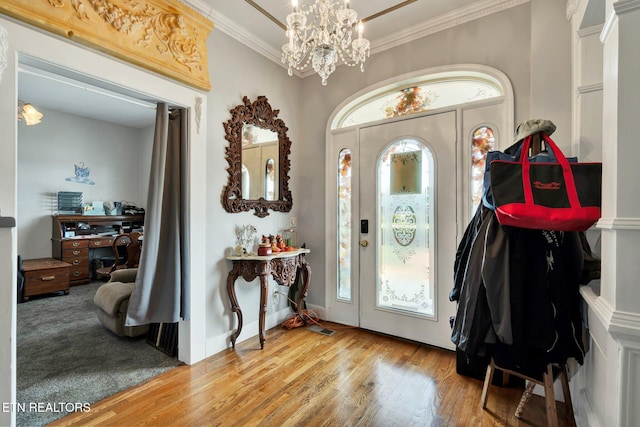 entryway featuring crown molding, an inviting chandelier, and light wood-type flooring