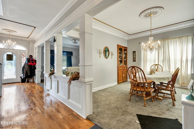 dining room featuring crown molding, a chandelier, wood-type flooring, and ornate columns