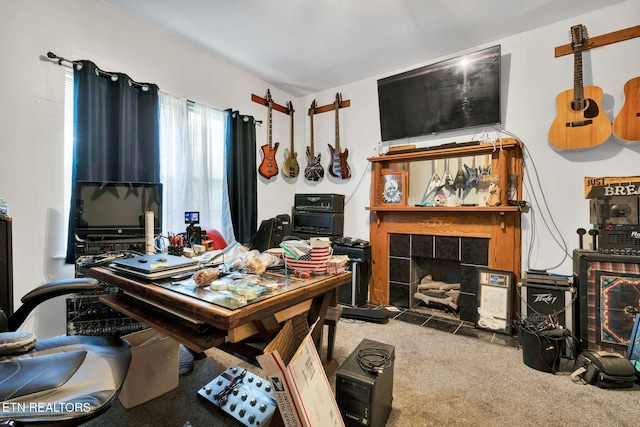 carpeted office featuring a tiled fireplace