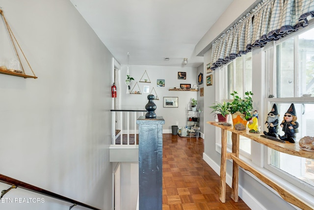 hallway featuring parquet flooring and plenty of natural light