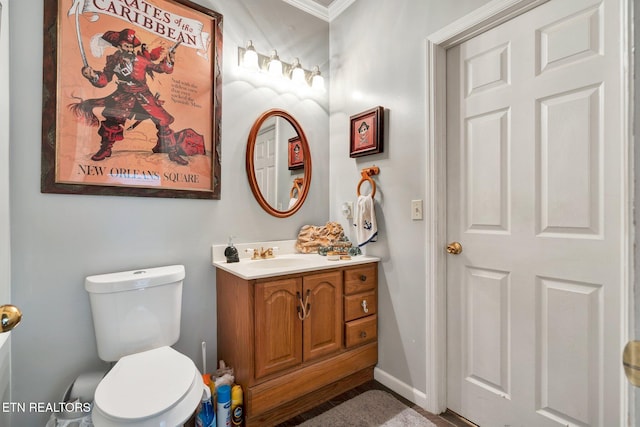 bathroom with vanity, crown molding, and toilet