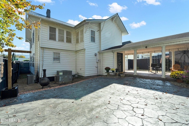 rear view of house featuring central air condition unit and a patio area