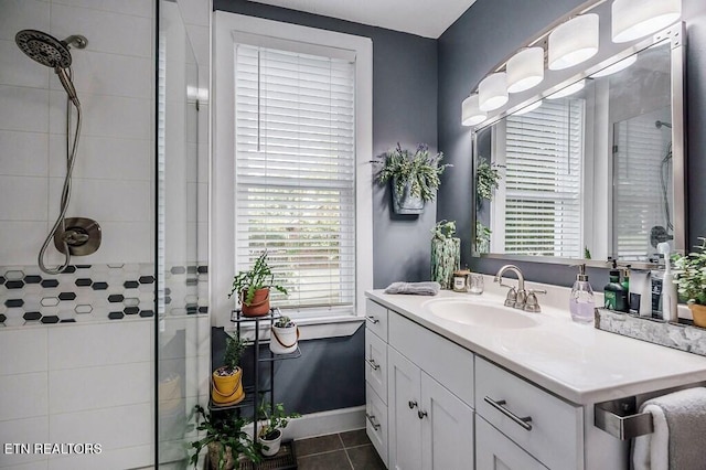 bathroom featuring a shower with door, vanity, and tile patterned flooring