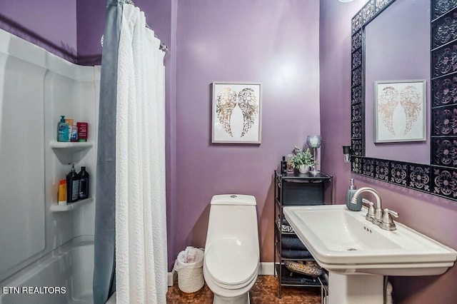 bathroom with toilet, walk in shower, and sink