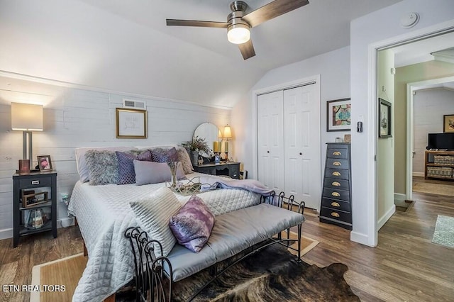 bedroom featuring dark hardwood / wood-style flooring, vaulted ceiling, a closet, and ceiling fan