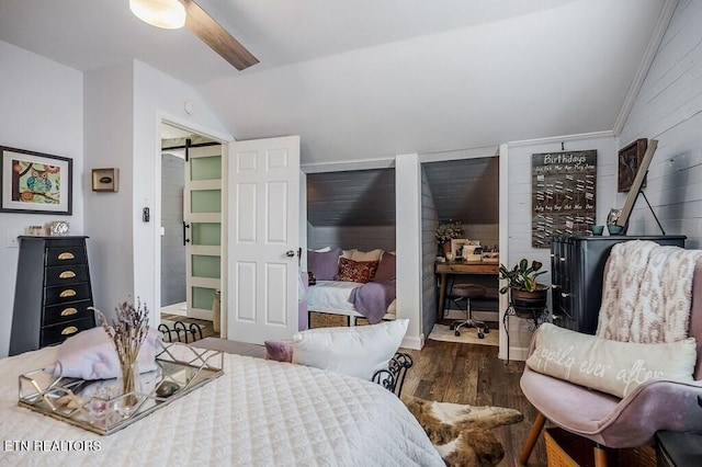 bedroom featuring dark wood-type flooring, ceiling fan, vaulted ceiling, and a barn door