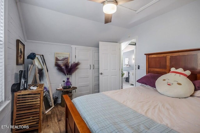 bedroom with crown molding, dark wood-type flooring, vaulted ceiling, and ceiling fan