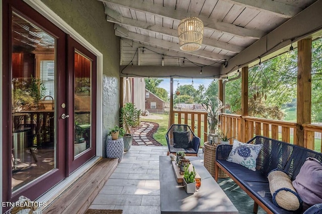 unfurnished sunroom featuring lofted ceiling with beams and wooden ceiling