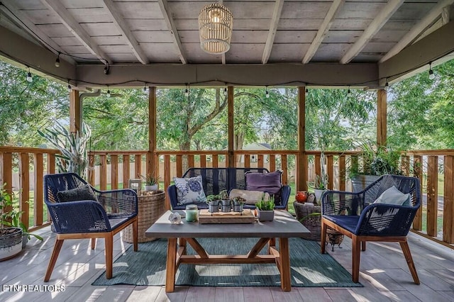 sunroom / solarium featuring beam ceiling and wooden ceiling