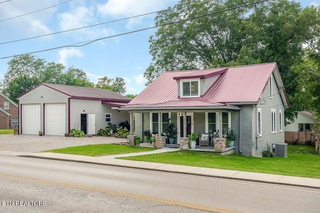 view of front of home with a front yard, a porch, cooling unit, and a garage