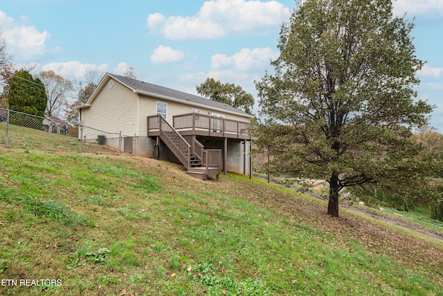 rear view of house with a lawn and a wooden deck