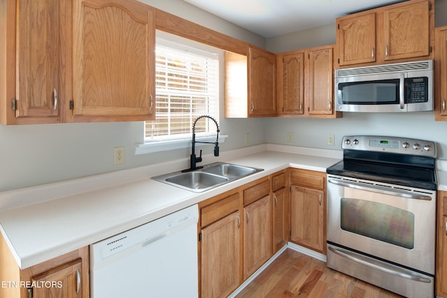 kitchen featuring light wood-type flooring, stainless steel appliances, and sink