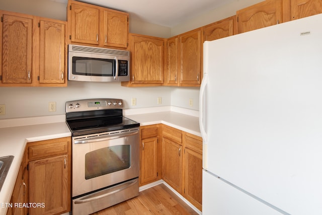 kitchen featuring light wood-type flooring and appliances with stainless steel finishes