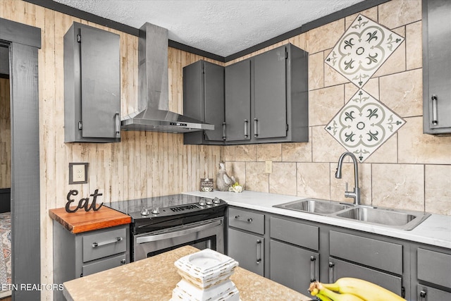 kitchen with sink, a textured ceiling, electric range, wall chimney exhaust hood, and gray cabinets