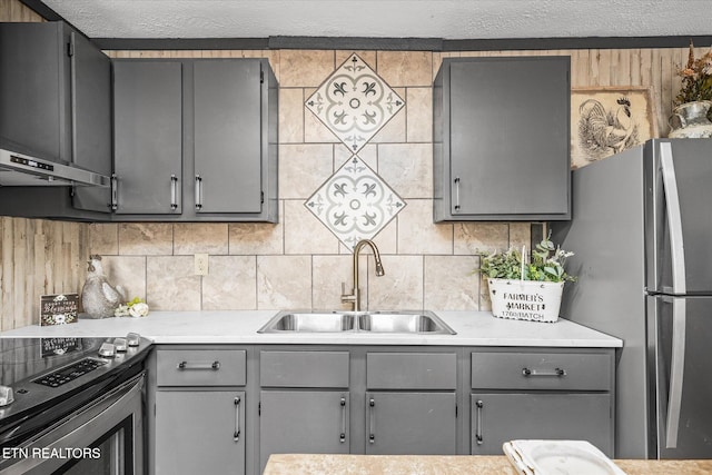 kitchen featuring appliances with stainless steel finishes, sink, backsplash, gray cabinets, and range hood