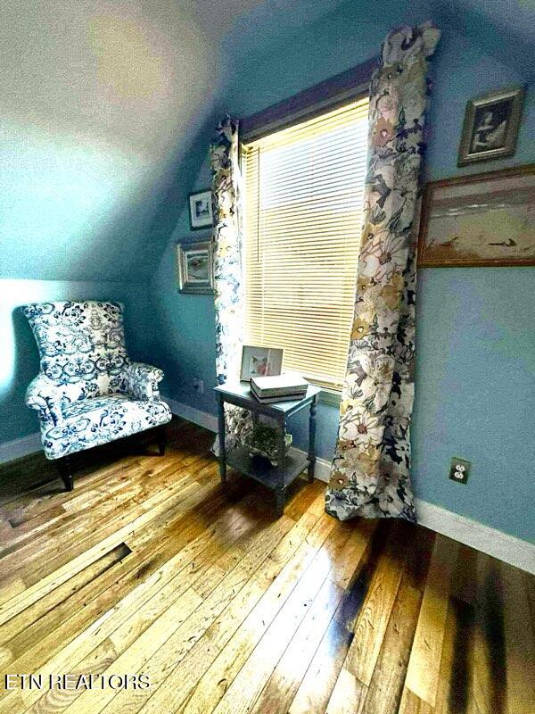 living area featuring hardwood / wood-style floors and vaulted ceiling