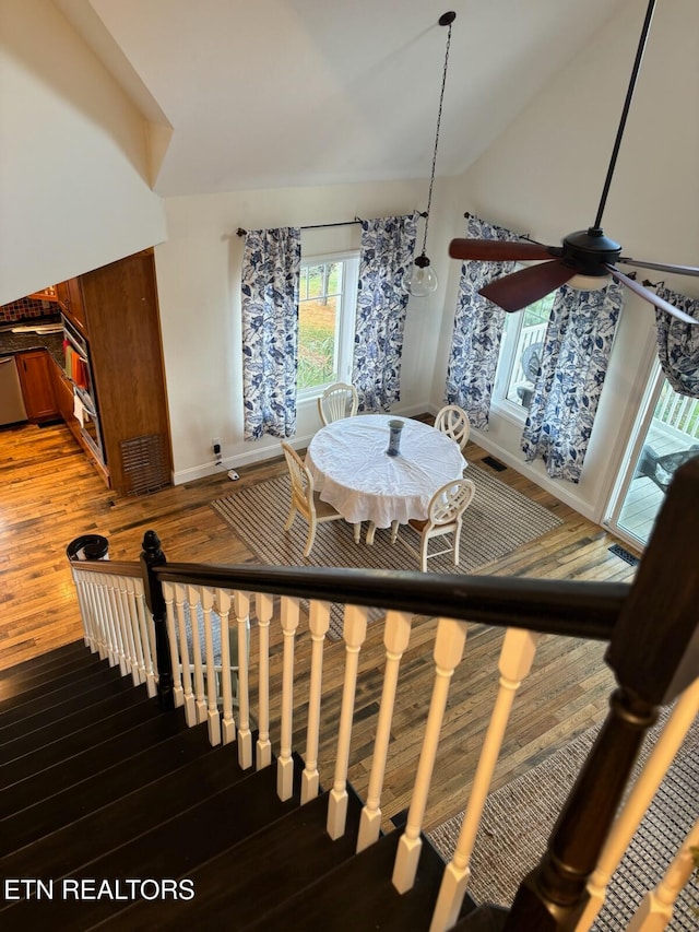 stairway with ceiling fan, hardwood / wood-style floors, and lofted ceiling