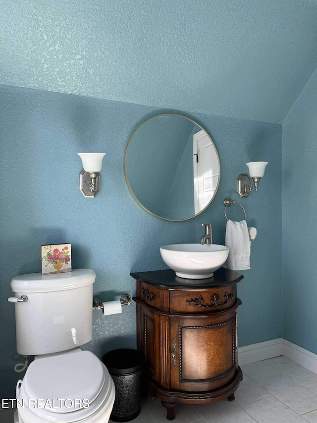 bathroom with toilet, vanity, and tile patterned floors