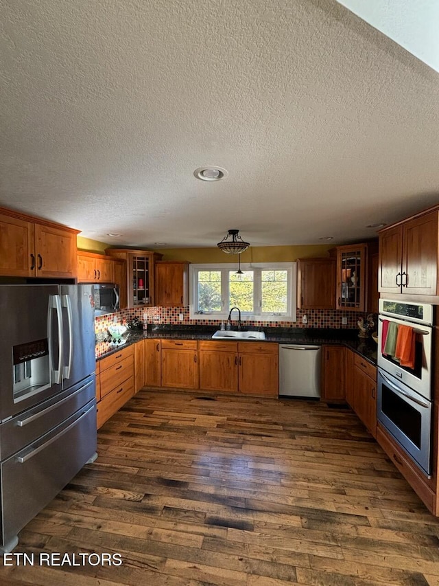 kitchen featuring a textured ceiling, sink, dark wood-type flooring, and appliances with stainless steel finishes