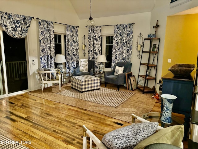 sitting room with hardwood / wood-style floors and vaulted ceiling