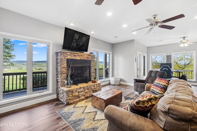 living room featuring a healthy amount of sunlight, dark hardwood / wood-style floors, and ceiling fan